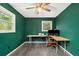 Green walled office space with wood-look floors, a desk and two sunny windows at 626 Mincey Ct, Stone Mountain, GA 30087