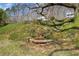 Landscaped backyard features stone-lined garden bed and slope leading to neighboring houses at 10845 Shallowford Rd, Roswell, GA 30075