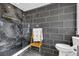Bathroom featuring a glass-enclosed shower, dark tiled walls, modern fixtures, and wood accents at 10845 Shallowford Rd, Roswell, GA 30075