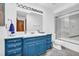 Bathroom with a blue vanity, a large mirror with decorative lights, and a shower/tub combination at 10845 Shallowford Rd, Roswell, GA 30075