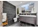 Modern bathroom with black tile, floating vanity with double sinks, and a large window providing natural light at 10845 Shallowford Rd, Roswell, GA 30075