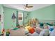 Charming bedroom painted a light green with carpet, ceiling fan, and lots of toys at 10845 Shallowford Rd, Roswell, GA 30075