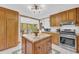 Traditional kitchen with wood cabinetry, granite counters, and adjacent sunroom with ample natural light at 10845 Shallowford Rd, Roswell, GA 30075