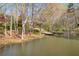 Picturesque pond view featuring a small dock and lush trees on the property at 10845 Shallowford Rd, Roswell, GA 30075