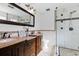 Modern bathroom featuring double sinks, and a frameless shower with decorative tile accents at 1647 Grandeus Sw Ln, Stone Mountain, GA 30087