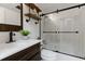 Modern bathroom with sleek fixtures, glass shower doors, and stylish vanity with industrial-style shelves at 1647 Grandeus Sw Ln, Stone Mountain, GA 30087