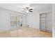 Bright bedroom with neutral walls, tile floor, a ceiling fan, large window, and built-in closet system at 1647 Grandeus Sw Ln, Stone Mountain, GA 30087