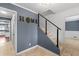 Hallway with blue walls, modern stair railing, and a view into the adjacent kitchen at 1647 Grandeus Sw Ln, Stone Mountain, GA 30087