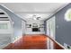 Open concept living room with hardwood floors, brick fireplace, ceiling fan, and natural light at 1647 Grandeus Sw Ln, Stone Mountain, GA 30087