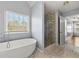 Spa-like bathroom with soaking tub, glass shower, and abundant natural light from the window at 2245 Friars Gate Dr, Lawrenceville, GA 30043