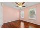 Bright, empty bedroom with hardwood floors, natural light, and a ceiling fan at 2245 Friars Gate Dr, Lawrenceville, GA 30043