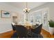 Bright dining room featuring hardwood floors, a bay window, and an elegant chandelier with seating for six at 2245 Friars Gate Dr, Lawrenceville, GA 30043