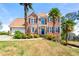 Beautiful two-story brick home with palm trees and a manicured lawn on a sunny day at 2245 Friars Gate Dr, Lawrenceville, GA 30043