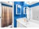 Bathroom with blue walls, shower with curtain, white cabinet and mirror at 4020 Balleycastle Ln, Duluth, GA 30097
