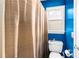 Cozy bathroom featuring blue walls, a toilet, and a shower behind a brown curtain at 4020 Balleycastle Ln, Duluth, GA 30097