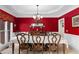 Elegant dining room with red walls, crown molding, chandelier and large window for ample natural light at 4020 Balleycastle Ln, Duluth, GA 30097