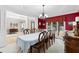 Elegant dining room with a long table, chandelier, adjacent living areas and natural light from large windows at 4020 Balleycastle Ln, Duluth, GA 30097