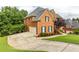 Brick home with an expansive driveway, lush green lawn, and well-manicured landscaping at 4020 Balleycastle Ln, Duluth, GA 30097