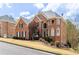 Stately brick home showcasing mature landscaping, a symmetrical facade, and ample natural light streaming through large windows at 4020 Balleycastle Ln, Duluth, GA 30097