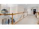 Upstairs hallway with carpet, wood railings, and bright natural light from windows at 4020 Balleycastle Ln, Duluth, GA 30097