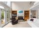 Comfortable living area with a stone fireplace, a tv, built-in shelving, and a view to the outdoor balcony at 4020 Balleycastle Ln, Duluth, GA 30097