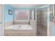 Luxurious primary bathroom with a separate shower, a soaking tub, and tile floors at 4020 Balleycastle Ln, Duluth, GA 30097