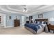 Carpeted primary bedroom with a tray ceiling, fan, and tasteful furnishings at 4020 Balleycastle Ln, Duluth, GA 30097