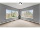 Bright bedroom with neutral carpet, two large windows offering scenic views at 5950 Bridge Stone Ct, Cumming, GA 30028
