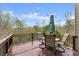 Outdoor deck with table, chairs, umbrella, and scenic views of lush greenery at 5950 Bridge Stone Ct, Cumming, GA 30028