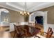 Dining room featuring hardwood floors, a coffered ceiling, and decorative chandelier at 5950 Bridge Stone Ct, Cumming, GA 30028