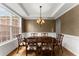 Elegant dining room with a large window, chandelier, and traditional wainscoting at 5950 Bridge Stone Ct, Cumming, GA 30028