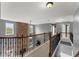 Open hallway featuring a brick fireplace accent wall and dark wooden railings at 5950 Bridge Stone Ct, Cumming, GA 30028