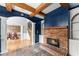Open-concept living room with blue walls, a brick fireplace, exposed wood beams and natural light at 5950 Bridge Stone Ct, Cumming, GA 30028