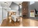 Spacious living room with hardwood floors, a stone fireplace, and open access to the kitchen at 5950 Bridge Stone Ct, Cumming, GA 30028
