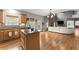 Spacious living room with wood floors, a stone fireplace, and an open kitchen at 5950 Bridge Stone Ct, Cumming, GA 30028