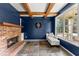 Cozy living room with blue walls, a brick fireplace, exposed wood beams and natural light at 5950 Bridge Stone Ct, Cumming, GA 30028