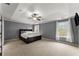 Spacious main bedroom with a tray ceiling, carpeted floor, and ample natural light at 5950 Bridge Stone Ct, Cumming, GA 30028