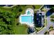Aerial view of a large community pool, clubhouse, splashpad, and surrounding greenery and walkway at 5950 Bridge Stone Ct, Cumming, GA 30028