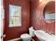 Stylish powder room with patterned wallpaper, a pedestal sink, and a framed mirror at 5950 Bridge Stone Ct, Cumming, GA 30028