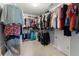 Well-organized walk-in closet filled with a variety of clothing items and carpeted floor at 5950 Bridge Stone Ct, Cumming, GA 30028