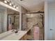 The bathroom features a large walk-in shower with a glass door, shower seat, grab bars, and pink towels at 338 Oak Leaf Pl, Acworth, GA 30102