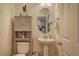 Stylish half bathroom featuring a pedestal sink, decorative mirror and cabinet storage at 338 Oak Leaf Pl, Acworth, GA 30102