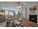 Cozy living room showcasing a fireplace, ceiling fan, hardwood floors and an open-concept floor plan at 338 Oak Leaf Pl, Acworth, GA 30102