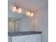 Bathroom featuring double vanity sinks, granite countertops, and a large mirror with lighting at 4265 Easter Lily Ave, Buford, GA 30519