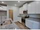 Well-lit kitchen with white cabinets, stainless steel appliances, and granite countertops at 4265 Easter Lily Ave, Buford, GA 30519