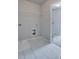 Bright laundry room features tile floors, utility sink, and overhead shelving for functional storage solutions at 4265 Easter Lily Ave, Buford, GA 30519