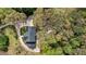 An aerial view shows the home nestled among trees with a curved driveway leading to the property at 6124 Kings Mountain Ct, Stone Mountain, GA 30087