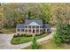 Stately two-story home with mature landscaping, circular driveway, and a grand entrance with columns at 6124 Kings Mountain Ct, Stone Mountain, GA 30087