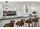 Stylish bar featuring a black countertop, backsplash, wood barstools, and hanging pendant lights at 6124 Kings Mountain Ct, Stone Mountain, GA 30087