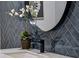 Close up of a bathroom with dark herringbone tile, round mirror, and a modern faucet at 6124 Kings Mountain Ct, Stone Mountain, GA 30087